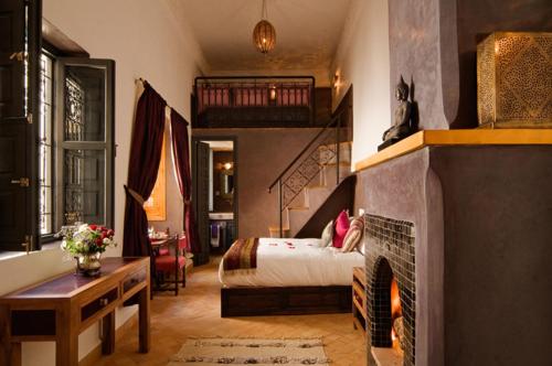 1 dormitorio con 1 cama y chimenea en Riad Cinnamon by Marrakech Riad, en Marrakech