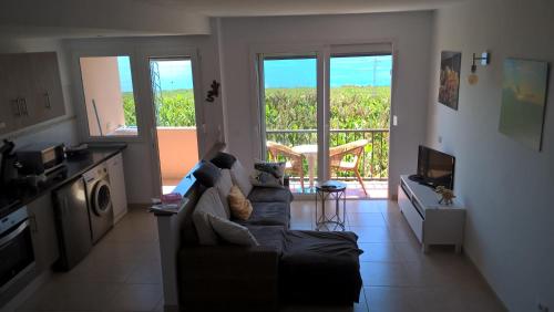 ein Wohnzimmer mit einem Sofa und einem Balkon in der Unterkunft Apartmento Atlantico in Tazacorte
