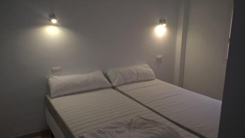 ein Schlafzimmer mit einem Bett mit zwei Leuchten in der Unterkunft Apartmento Atlantico in Tazacorte