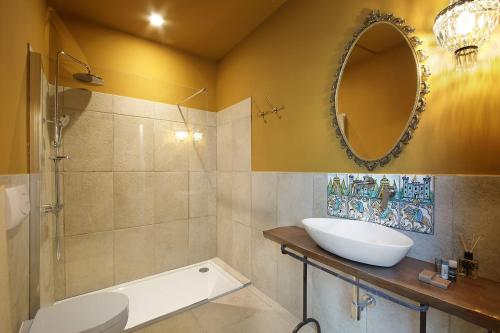 La salle de bains est pourvue d'un lavabo et d'un miroir. dans l'établissement B&B Sikuli e Sikani, à Syracuse