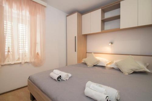 a bedroom with a large bed with towels on it at Guest House Holiday in Korčula