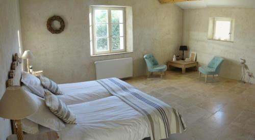 - une chambre avec un lit et deux chaises bleues dans l'établissement Mas du Vieux Tilleul, à Vaison-la-Romaine