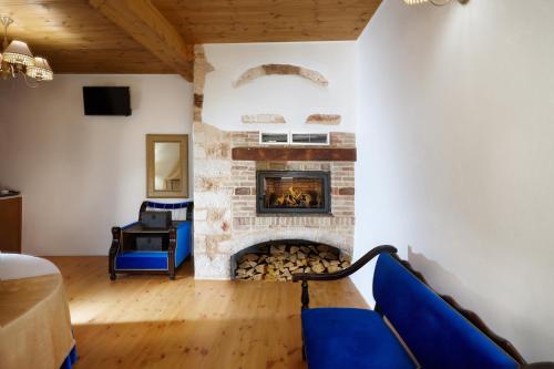 - un salon avec une cheminée et un canapé bleu dans l'établissement Casa Perla Suites, à La Canée