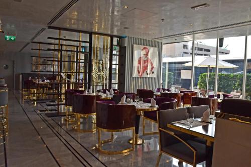 una sala da pranzo con tavoli, sedie e finestre di Tamani Marina Hotel & Apartments a Dubai