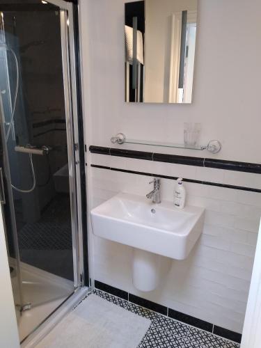a bathroom with a sink and a mirror and a shower at Dunseverick Ramblers Rest in Bushmills