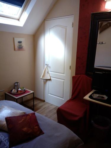 a room with a bed and a door and a chair at La Gentilhommière du Château de Ragnies in Ragnies
