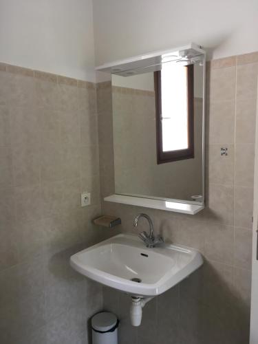 a bathroom with a white sink and a mirror at Domaine Valdaronu in Sainte-Lucie de Porto-Vecchio