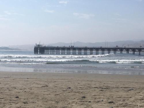 a beach with a pier in the ocean at Bungalows Cerro Azul in Cerro Azul