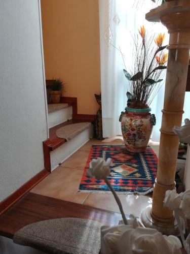 a living room with a vase on the floor at Da Mamma e Papà Sirolo in Sirolo