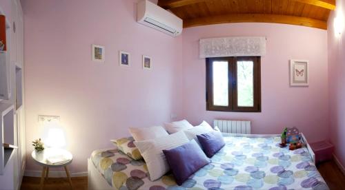 een slaapkamer met een bed met kussens en een raam bij La Casita del Almendro in Cuenca