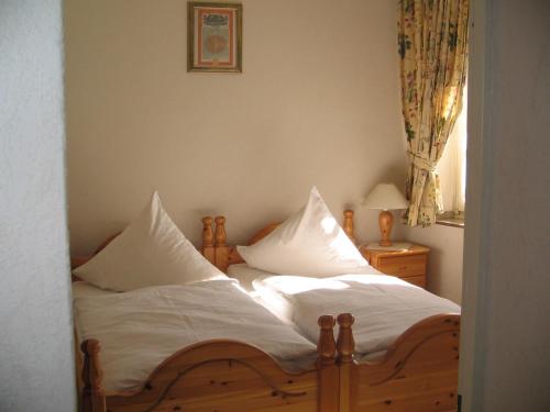 una camera con 2 letti con lenzuola e cuscini bianchi di Hotel Alt Wassenberg a Wassenberg