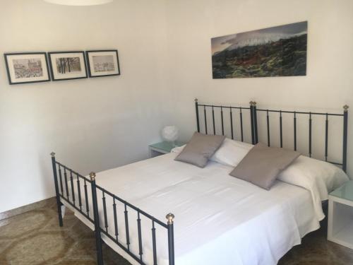 Schlafzimmer mit einem Bett mit weißer Bettwäsche und Kissen in der Unterkunft Villa Rosa Marina in Rosa Marina