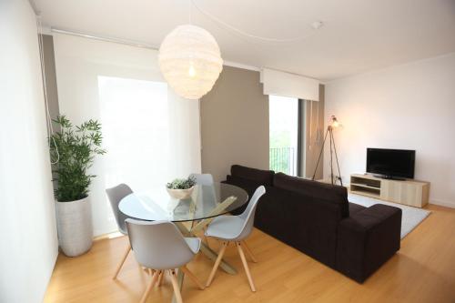 a living room with a black couch and a glass table at Enjoy Lisbon Martim Moniz 1 in Lisbon