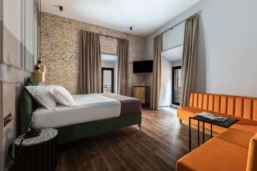 ein Hotelzimmer mit einem Bett und einem Sofa in der Unterkunft Chapter Roma in Rom