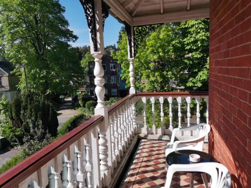 a porch with a white railing and two white chairs at Lincoln House in Bournemouth