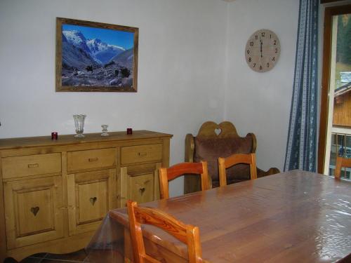 une salle à manger avec une table et une horloge au mur dans l'établissement BOROT, à Lanslebourg-Mont-Cenis