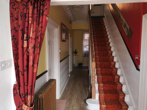 a stairway with red curtains and a red wall at Lincoln House in Bournemouth