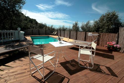 a patio with two chairs and a table and a pool at Tenuta Camporosso in Massa Lubrense