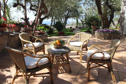 a group of chairs and a table with a bowl of fruit at Tenuta Camporosso in Massa Lubrense