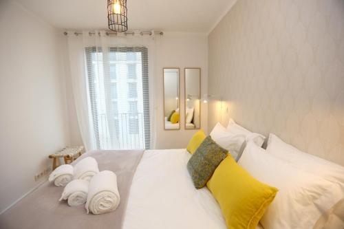 a white bedroom with a large bed with yellow and white pillows at Enjoy Lisbon Martim Moniz 1 in Lisbon