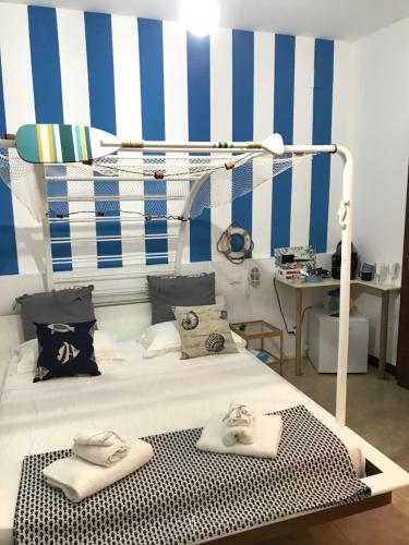 a bedroom with a white bed with blue and white stripes at Il Giardino di Gianni in La Spezia