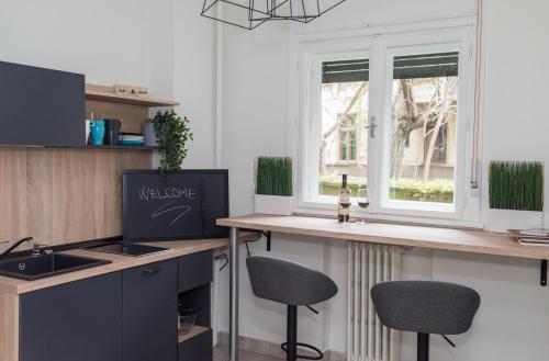 a kitchen with a counter with two stools next to a window at Explore the City from Its Center in a Chic Balcony Apartment in Bucharest