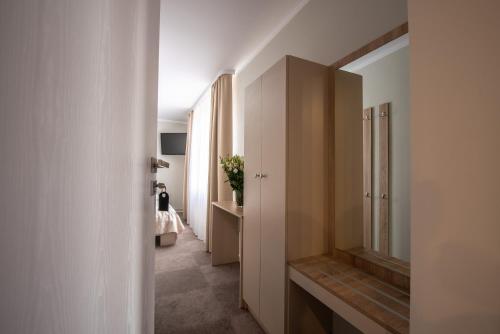 a hallway with a mirror and a room with a bed at Biały Gościniec in Ciechanów