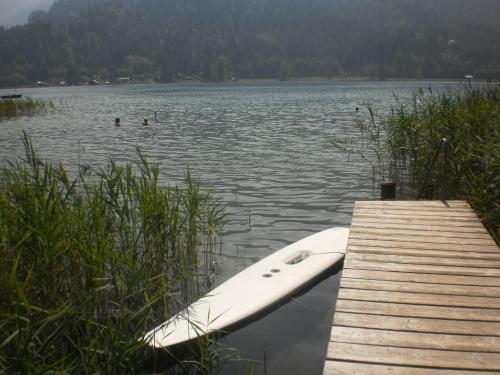 a boat sitting on the water next to a dock at Haus Birke in Weissensee