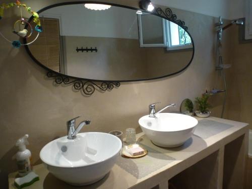 une salle de bain avec deux lavabos et un grand miroir dans l'établissement Shanti House Luberon, à Cheval-Blanc