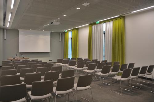 a conference room with chairs and a white screen at Link124 Hotel in Parma