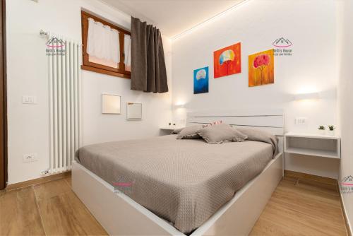 a bedroom with a bed in a white room at Garden Beth's House in Brenzone sul Garda