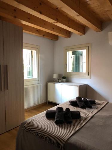 a bedroom with a large bed with two windows at Interno 1 in Treviso