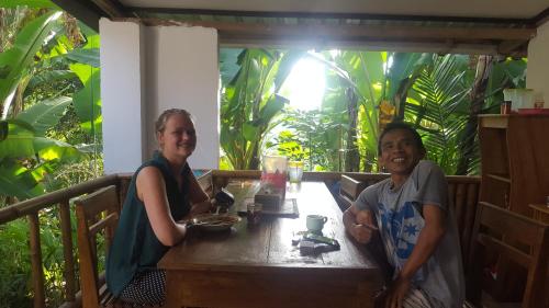 a man and a woman sitting at a table at Tetebatu Indah Homestay in Tetebatu