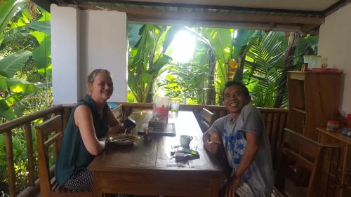 a man and a woman sitting at a table at Tetebatu Indah Homestay in Tetebatu