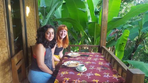 two women sitting at a table with a table cloth at Tetebatu Indah Homestay in Tetebatu