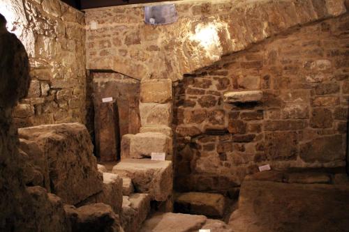 Une ancienne chambre en pierre avec des escaliers se trouve dans un bâtiment. dans l'établissement S.Andrea degli Armeni Dimora di Charme, à Tarente