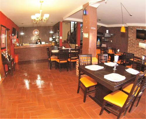 a restaurant with a table and chairs and a bar at Hotel Real de la Sierra in Mazamitla