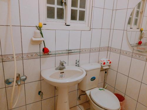 a small bathroom with a toilet and a sink at Flourish B&B in Gukeng