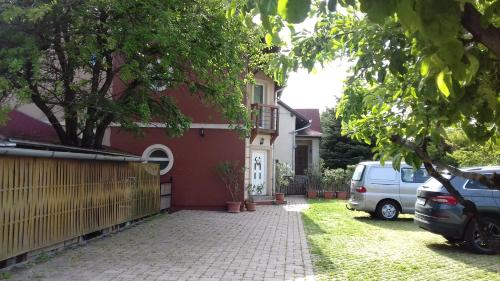 a house with a car parked in the driveway at Sorompó Vendégház in Balatonkenese