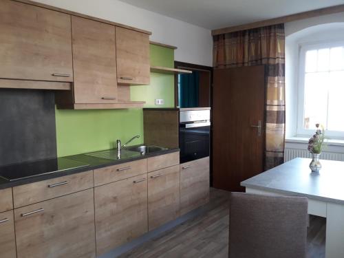a kitchen with wooden cabinets and a sink at Hartl Apartments in Kirchberg ob der Donau