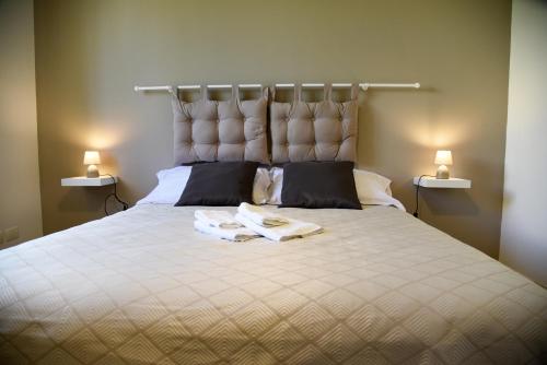 una camera da letto con un grande letto con asciugamani di Le Colonne a Locorotondo