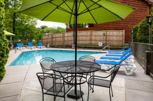 a table and chairs with an umbrella next to a pool at Twin Mountain Inn & Suites in Pigeon Forge