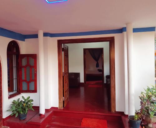 a room with a hallway with blue walls and a door at Breeze Guest House in Trincomalee