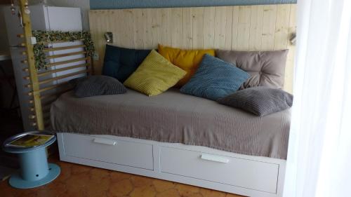 Una cama con muchas almohadas en una habitación. en Studio meublé aux Sablettes La Seyne sur Mer, en La Seyne-sur-Mer