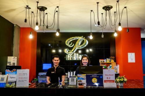 two people standing behind a counter in a store at PP@Hotel Rangsit in Pathum Thani