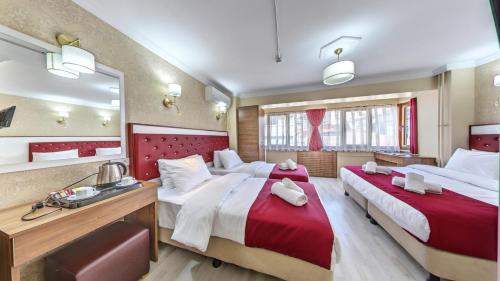 a hotel room with two beds and a mirror at Cihangir Palace Hotel in Istanbul