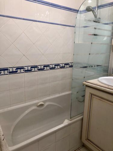 une salle de bain avec une baignoire et un lavabo dans l'établissement Le Noisetier, à Cavalaire-sur-Mer