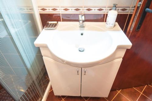 a white sink in a bathroom with a remote control on it at Apartments Milena in Tivat