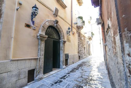 an alley with an arch in the side of a building at S.Andrea degli Armeni Dimora di Charme in Taranto