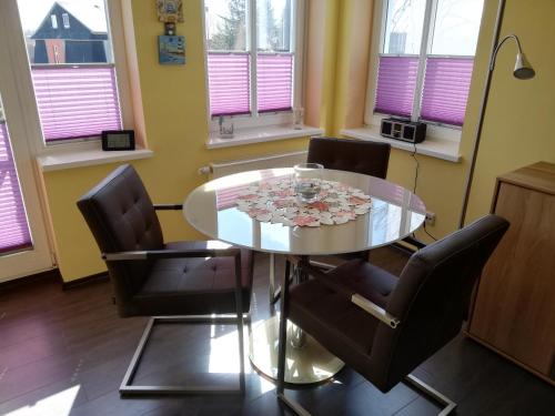 a dining room with a glass table and chairs at Appartement Blaue Welle in Bansin